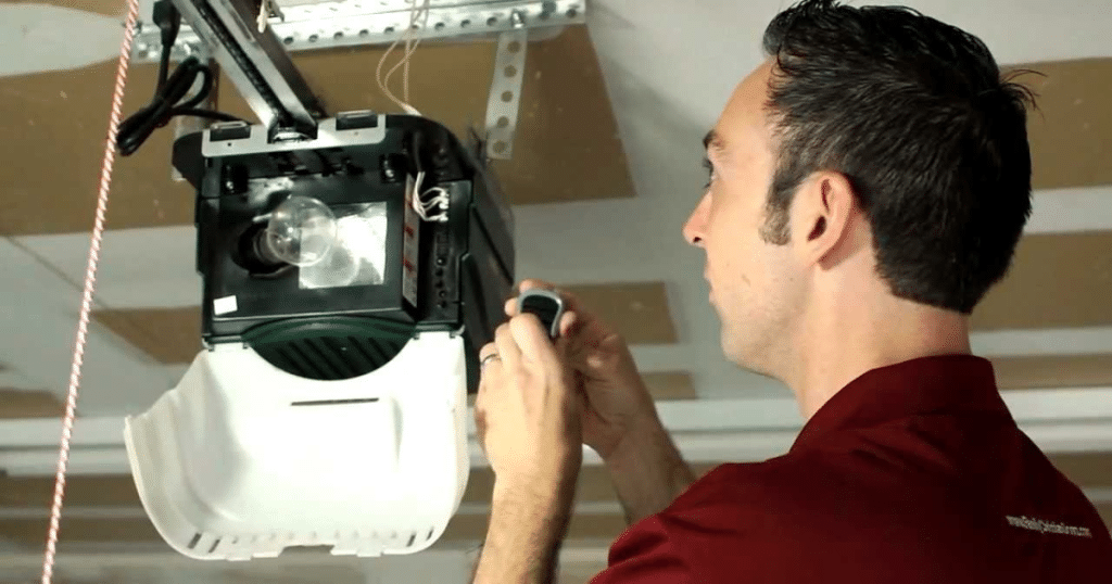 Man repairs garage door opener device.